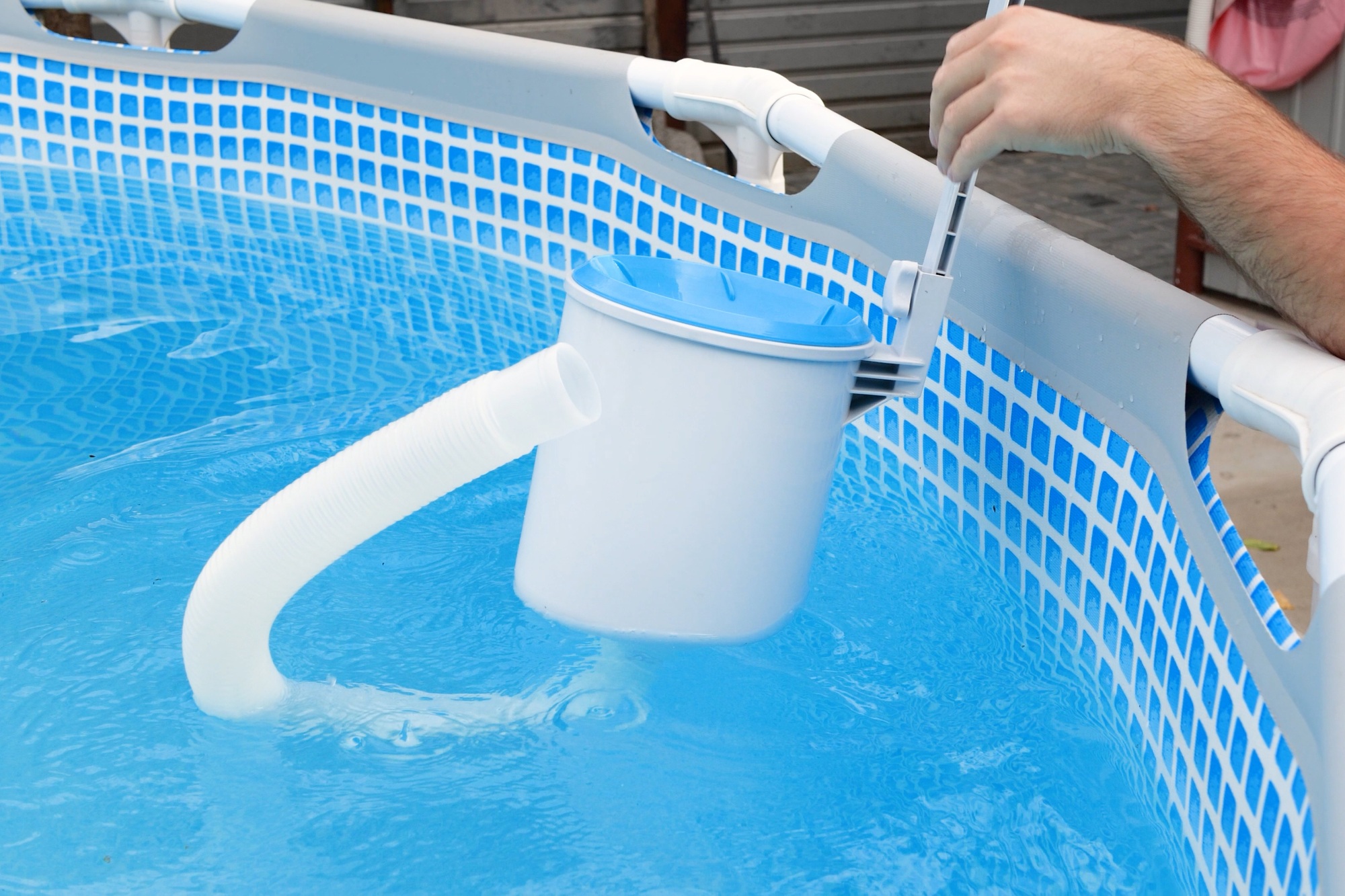 Man cleans skimmer for the frame pool. Contaminated pool cleaning concept